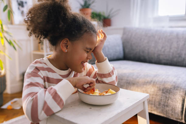 istock Afro-American Girl Eating Fruit 1392735703