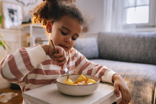 istock Afro-American Girl Eating Fruit 1392735706