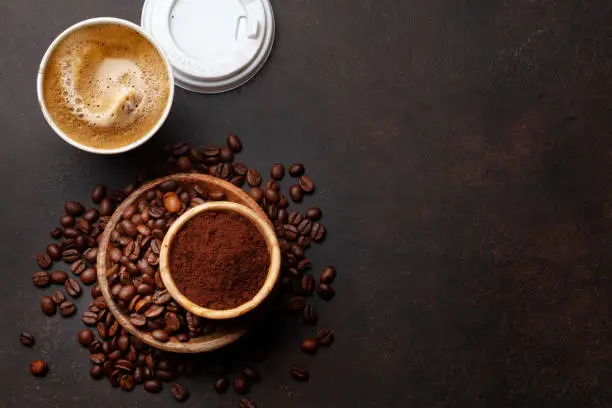Photo of Takeaway cup, roasted coffee beans and ground coffee