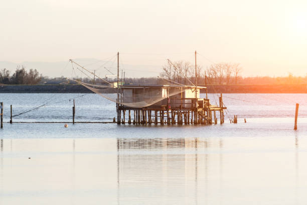 A peaceful view of a wooden house stretching into the sea,