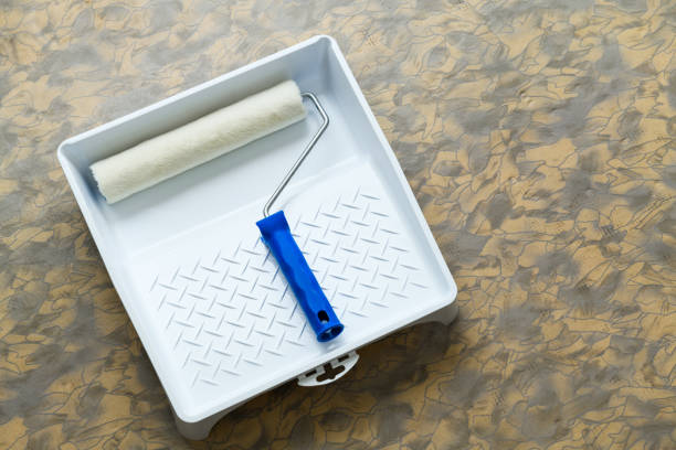 istock Paint set: roller in tray (bath),  close-up. Repair tools lies on floor 1392743629