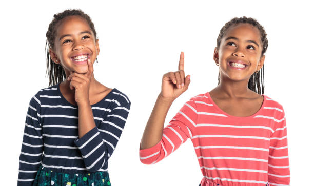 istock Two Adorable african twin girl on studio white background pointing something 1392744108