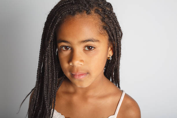 istock Adorable sad african little girl on studio gray background 1392744321