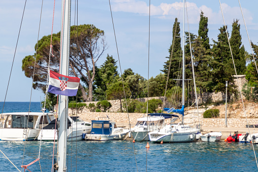 Mandre jetty, Croatian flag in the foreground, Pag island, Croatia