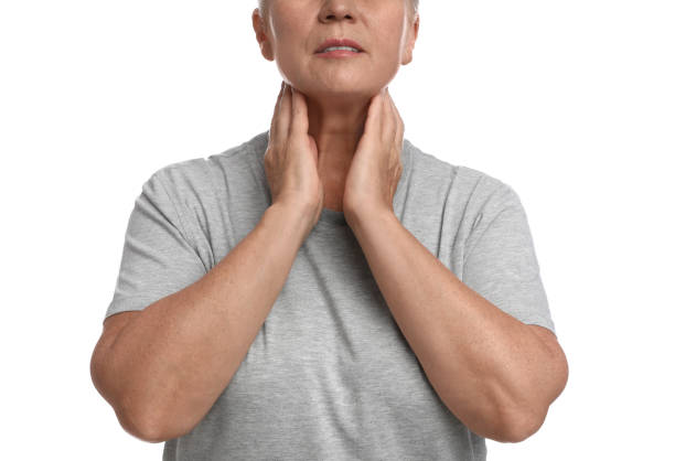istock Mature woman doing thyroid self examination on white background, closeup 1392748731