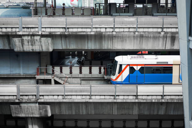 Bangkok Mass Transit System (BTS) in close up section view is driven across the Siam Square Station from Siam Square One Building view. Bangkok, Thailand.