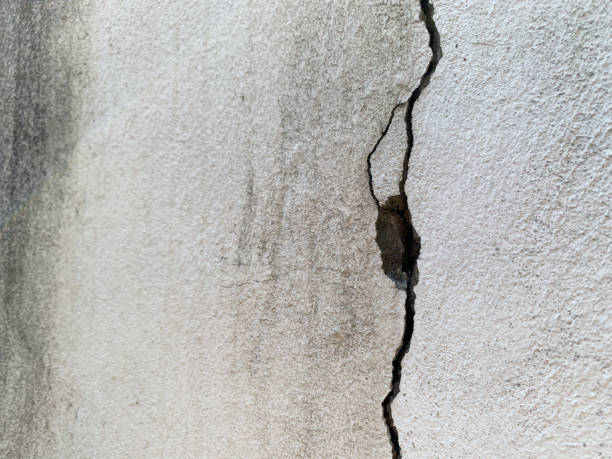 istock Large crack on white cement wall, Close up view 1392751466