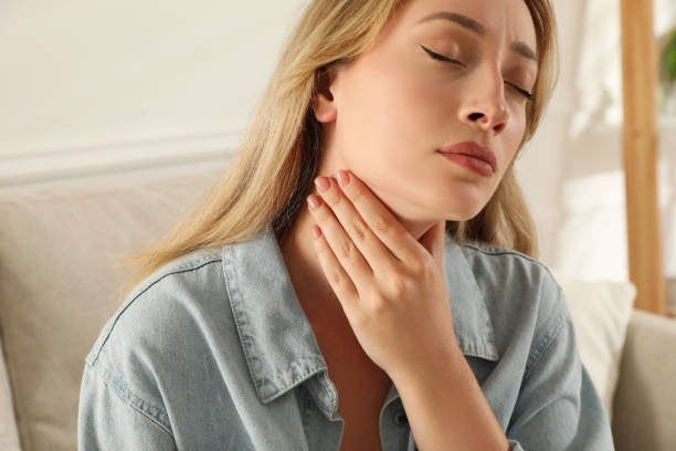 istock Young woman doing thyroid self examination at home 1392753059