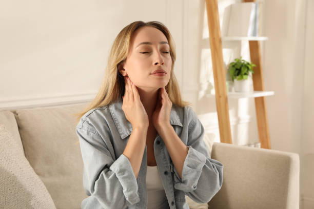 istock Young woman doing thyroid self examination at home 1392753537