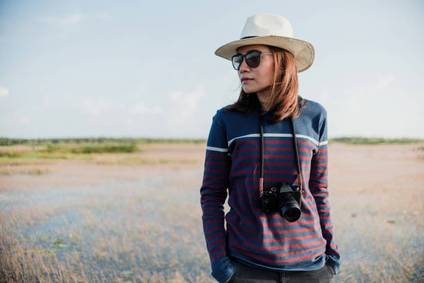 istock Asian female photographer admiring the scenery 1392760310