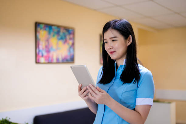 istock Asian female therapist with scrubs using digital tablet 1392763720