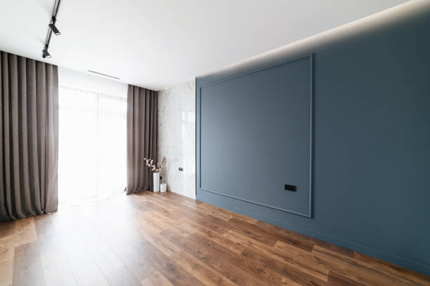 istock Large, empty, new, stylish room with blue wall and wood floor 1392764700
