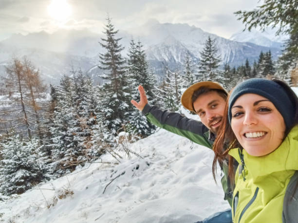 jovem casal tira uma selfie enquanto snowshoeing no inverno - snowshoeing winter sport snowshoe hiking - fotografias e filmes do acervo