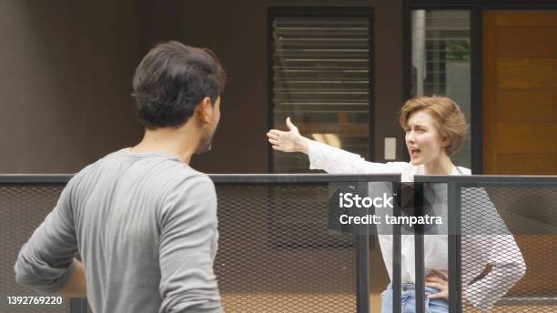 An Angry Neighbor Shouting Blaming Yelling At Each Other In Their Homes In Village People Neighborhood Argument Stock Photo - Download Image Now