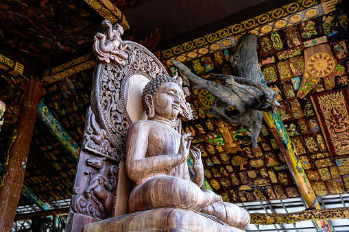 Buddha statue carved from wood that is so beautiful for Thai people to travel respect praying holy deity mystery at Khao Tham Prathun temple at Ban Rai, Uthai Thani province, Thailand
