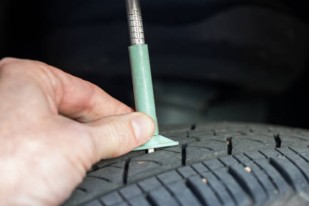 istock Checking tread depth on a tire with a tire gauge 1392773835