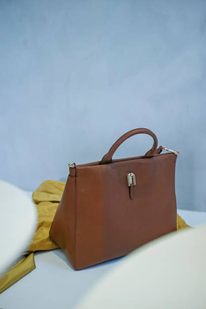istock Brown bag and yellow scarf on white stool 1392774208