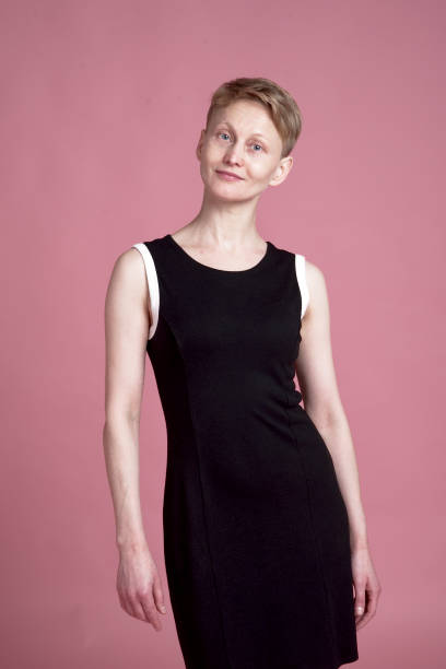 Portrait of young woman Studio portrait of young woman with short hair with black dress on pink background costantino stock pictures, royalty-free photos & images