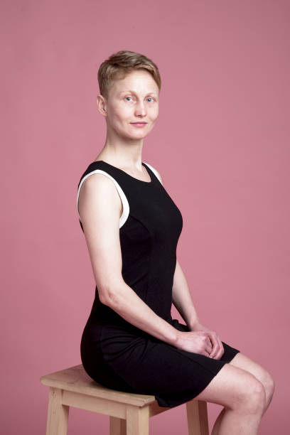 Portrait of young woman Studio portrait of young woman with short hair with black dress on pink background costantino stock pictures, royalty-free photos & images