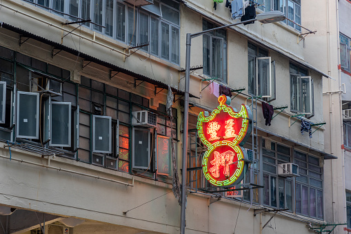 Hong Kong - April 21, 2022 : Yik Fung Pawn Shop in To Kwa Wan, Kowloon, Hong Kong. The iconic neon green and red signs can be seen in most of Hong Kong's 18 districts, they are some of the oldest businesses in Hong Kong.