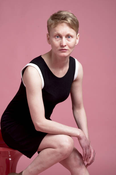 Portrait of young woman Studio portrait of young woman with short hair with black dress on pink background costantino stock pictures, royalty-free photos & images