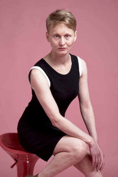 Portrait of young woman Studio portrait of young woman with short hair with black dress on pink background costantino stock pictures, royalty-free photos & images