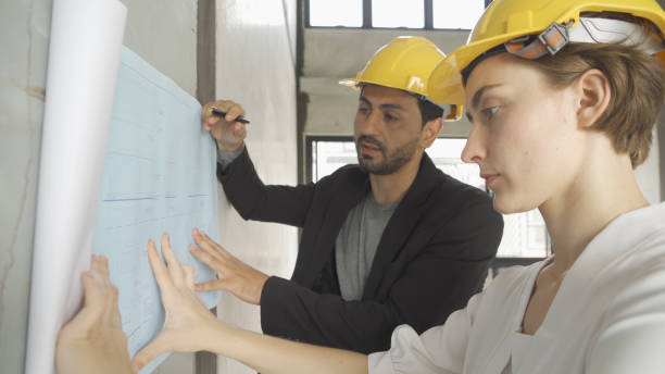 istock A group of multi ethnic business designer team talk, communicate, discuss, and work in meeting room on construction site, present ideas to colleagues. People lifestyle. Corporation 1392775950