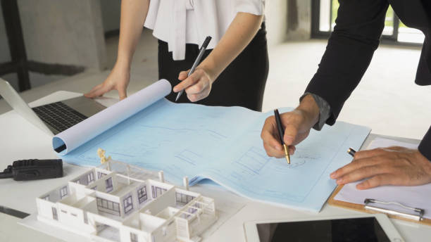 istock A group of multi ethnic business designer team talk, communicate, discuss, and work in meeting room on construction site, present ideas to colleagues. People lifestyle. Corporation 1392775991