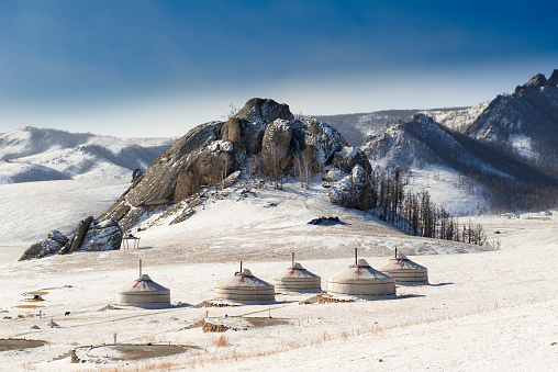 Panorama over a snowy winter landscape in Mongolia, Central Asia with a yurt camp in the foreground