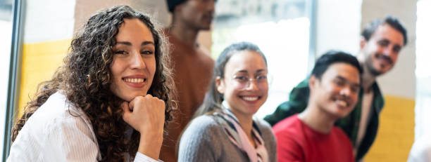 Horizontal banner or header with university students multiethnic team studying together on a new project in creative coworking classroom - Bright filter with focus on first woman on left