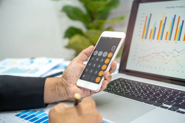 istock Asian accountant working and analyzing financial reports project accounting with chart graph and calculator in modern office, finance and business concept. 1392780442