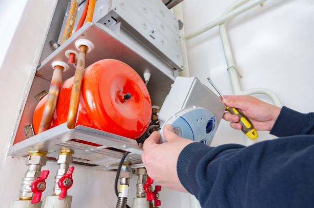 Service engineer repairing gas boiler of heating system. stock photo