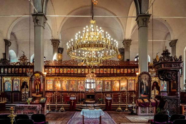 Wide angle color image of an ornately decorated ceiling and interior of an Orthodox church.