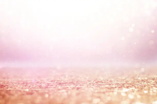 Photo of background of abstract gold, pink and silver glitter lights. defocused