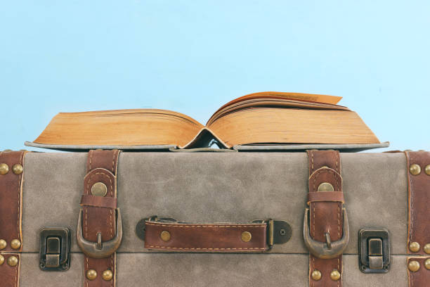 istock Old vintage suitcase and stack of books 1392783367