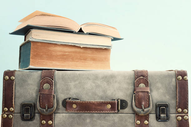 istock Old vintage suitcase and stack of books 1392783376