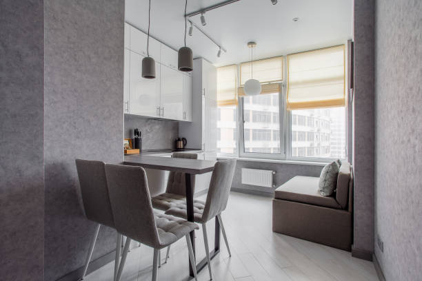 istock Clean kitchen in a small cozy contemporary studio apartment. Table and chairs in the foreground. Built in household appliance 1392784210