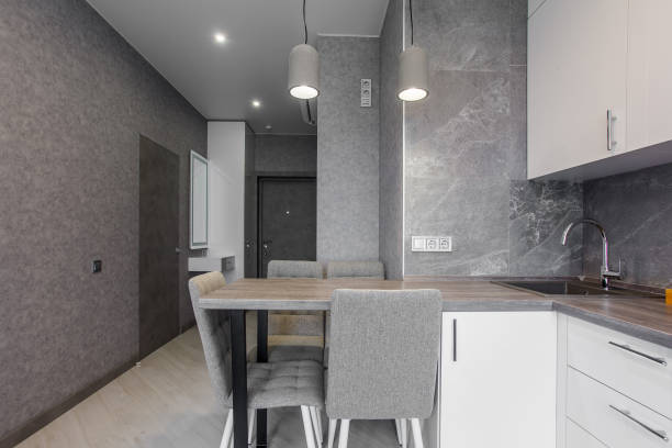 istock Clean kitchen in a small cozy contemporary studio apartment. Table and chairs in the foreground. Built in household appliance 1392784241