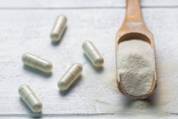istock collagen in tablets and powder on wooden white background. 1392784549