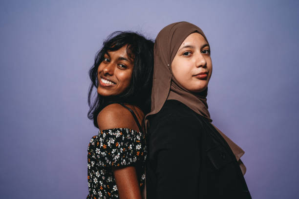 istock Two friends are standing back to back against a purple background 1392785985
