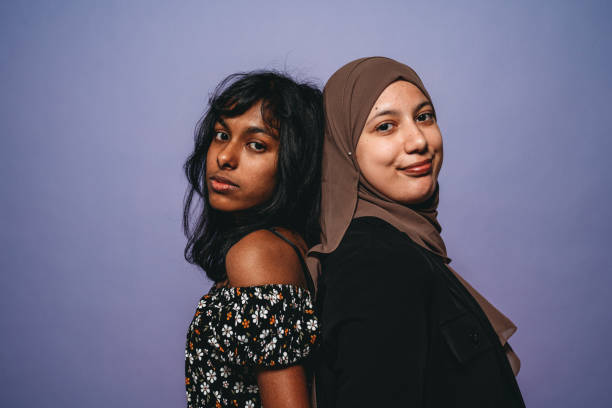istock Two friends are standing back to back against a purple background 1392785988