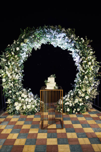 istock Beautiful wedding cake with flowers and a large wedding arch. 1392787011