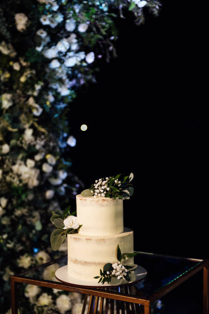 istock Beautiful wedding cake with flowers and a large wedding arch. 1392787041