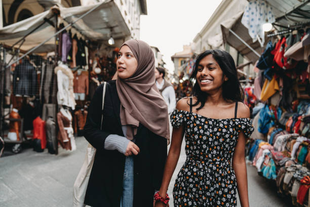 Two friends are walking in San Lorenzo market in Florence, Italy Two friends are walking in San Lorenzo market in Florence, Italy. They are shopping together. middle eastern clothes stock pictures, royalty-free photos & images