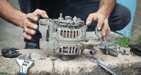 Man repairs car alternator. Technology. Industry