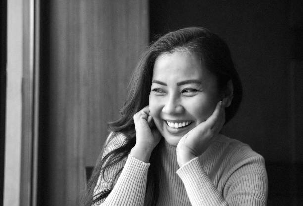 Portrait of Asian woman smiling - black and white stock photo