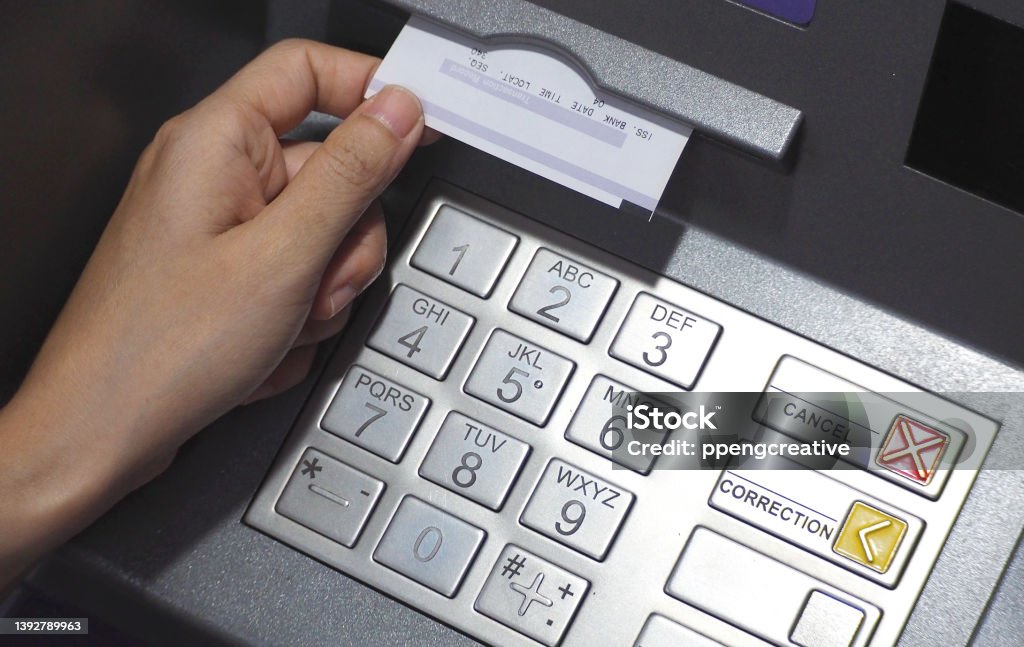ATM button close-up and paper transaction. ATM button close-up and paper transaction deposit pay slip and hand. ATM Stock Photo