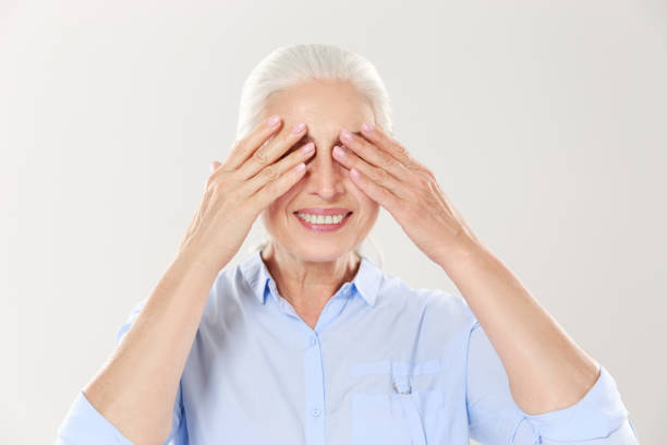 istock Senior grey-haired woman covering her eyes with both hands 1392790457