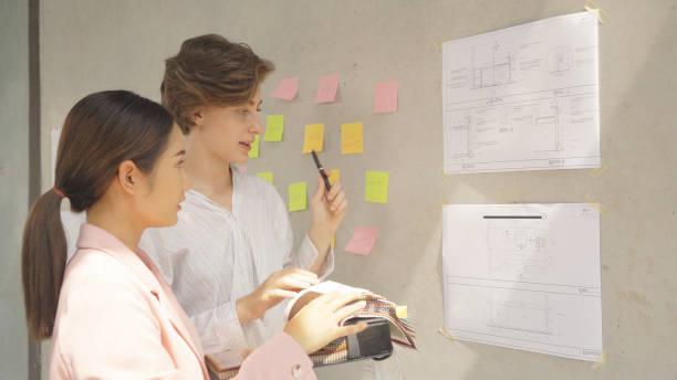 istock A group of multi ethnic business designer team talk, communicate, discuss, and work in meeting room on construction site, present ideas to colleagues. People lifestyle. Corporation 1392793286