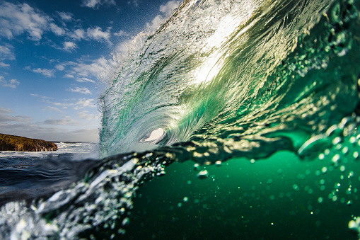 Bright green transparent wave forming in front of sunlight